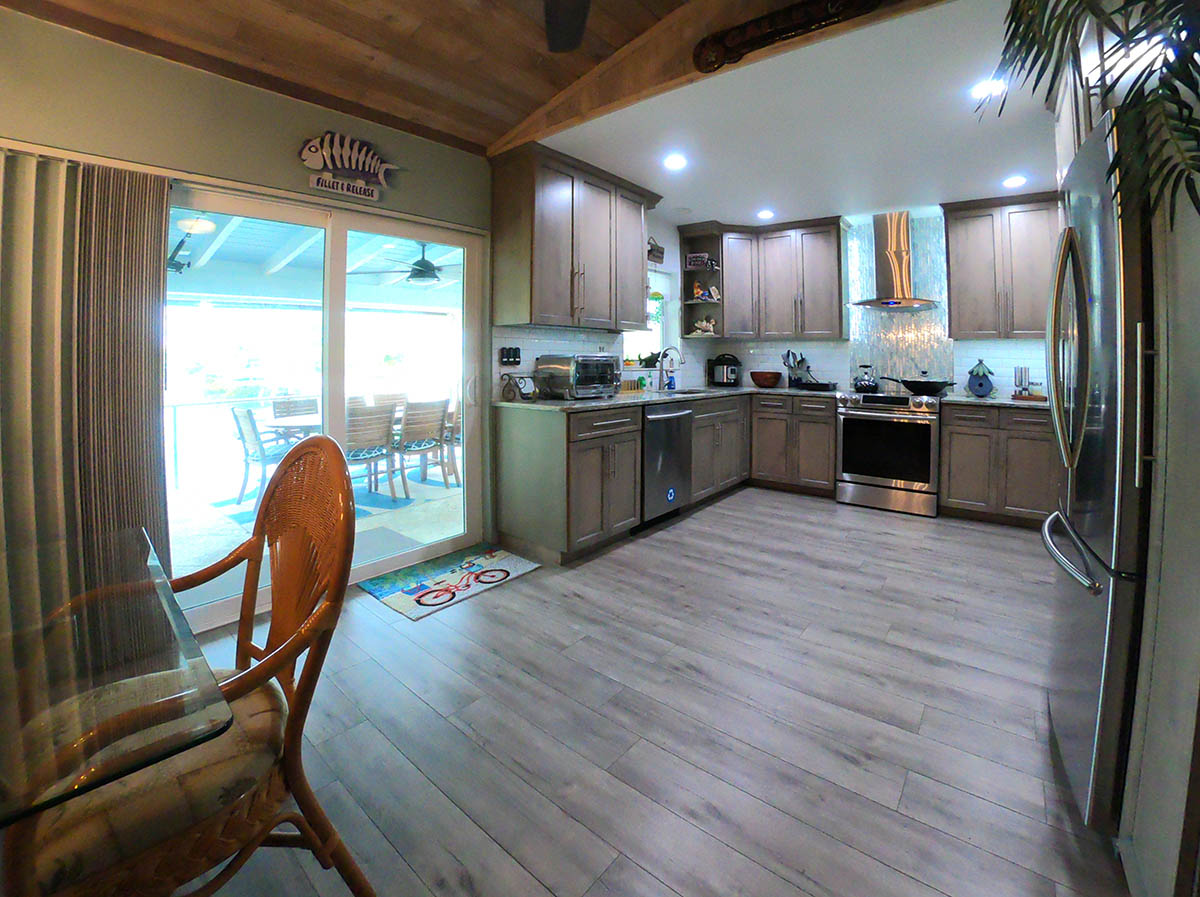 Custom quartz and hardwood Kitchen is fully equipped, well lit for mood and function and overlooks the water and the outdoor dining table.